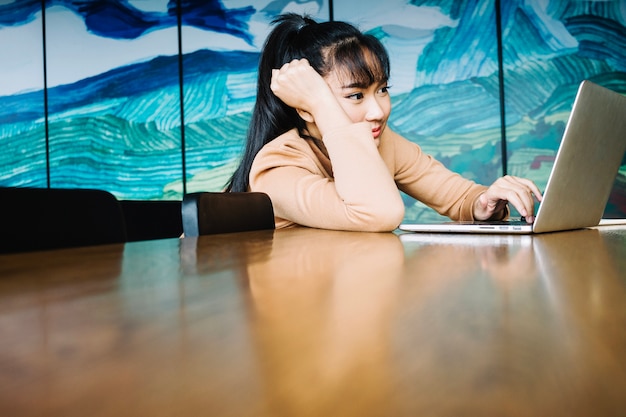 Mujer cansada con la computadora portátil