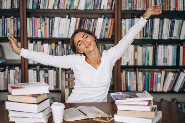 Mujer cansada estirando en la biblioteca