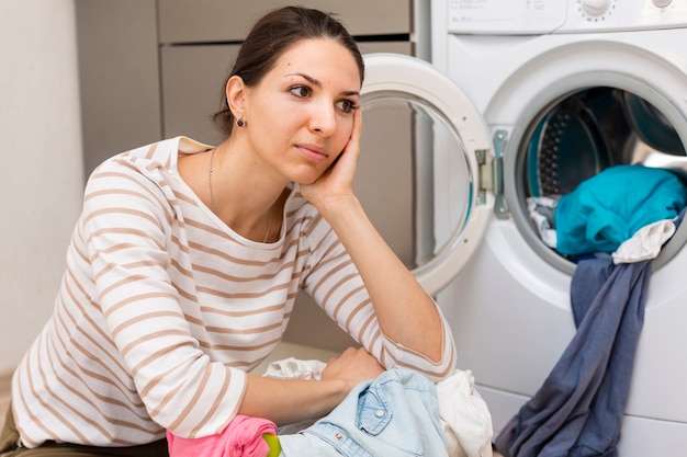 Mujer cansada lavando ropa