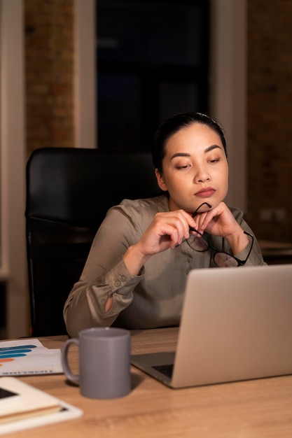 Foto gratuita mujer cansada trabajando hasta tarde en la oficina