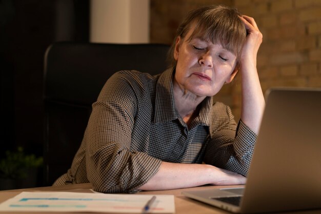 Mujer cansada trabajando hasta tarde por un plazo