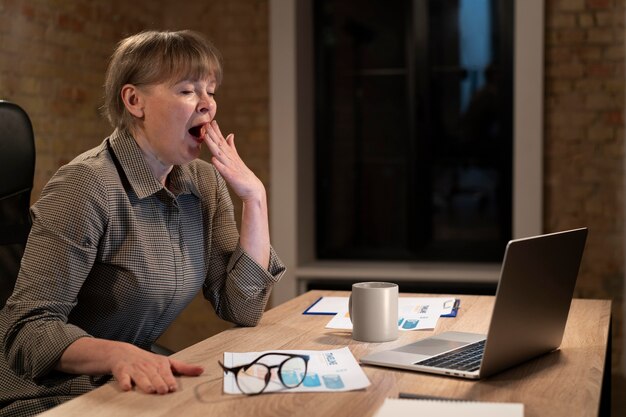 Mujer cansada trabajando hasta tarde por un plazo