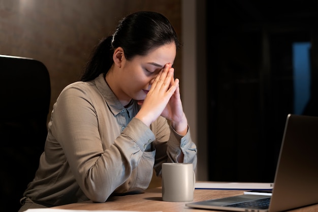 Mujer cansada trabajando hasta tarde para un proyecto