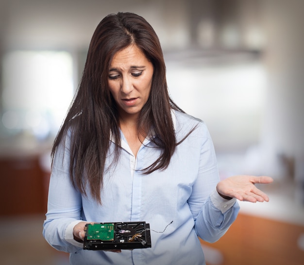 Mujer con cara confundida mirando un disco duro