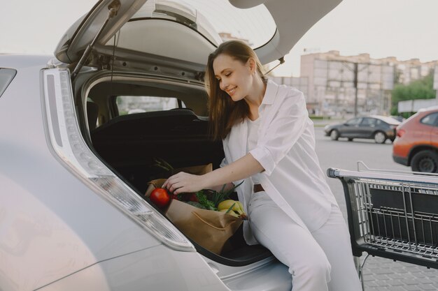 Mujer carga electro car en la gasolinera eléctrica