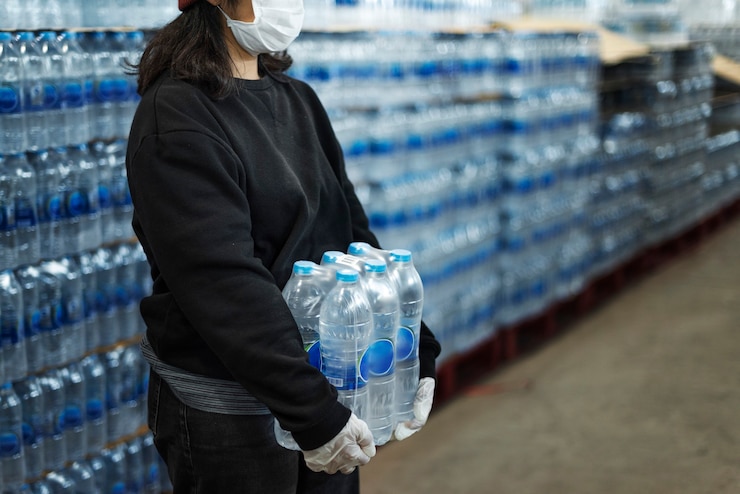 Foto gratuito mujer cargando agua potable con guantes durante la pandemia de coronavirus