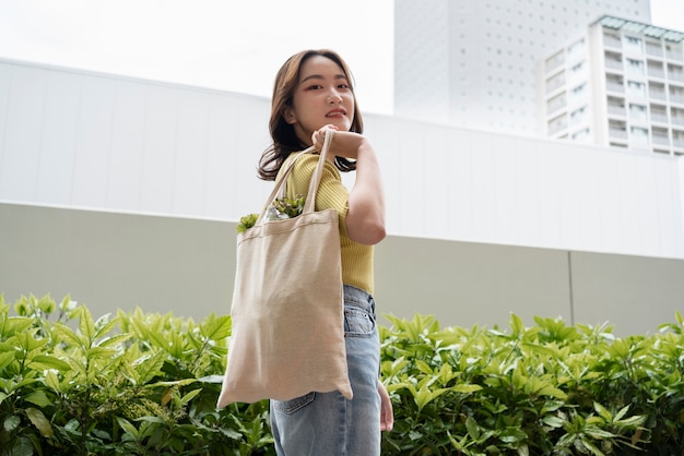 Mujer cargando comestibles en una bolsa de asas de tiro medio