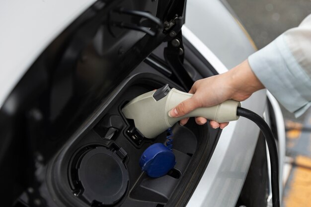 Mujer cargando su auto eléctrico en la estación