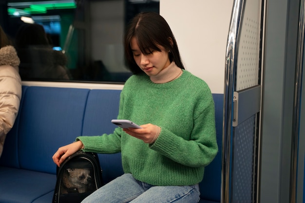 Foto gratuita mujer cargando a su mascota en el metro