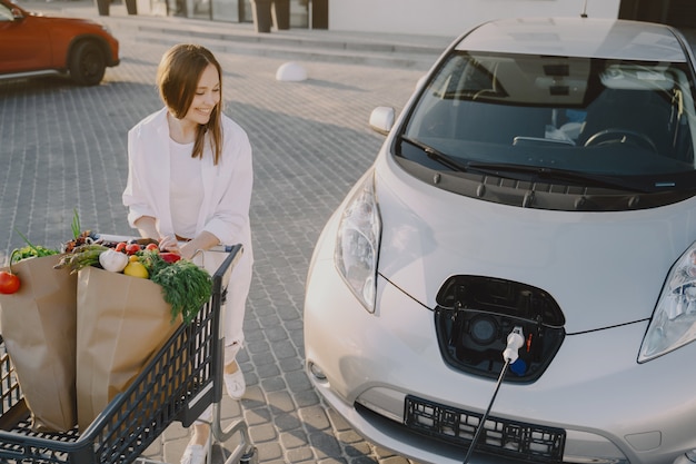 Foto gratuita mujer con un carrito de compras en su auto