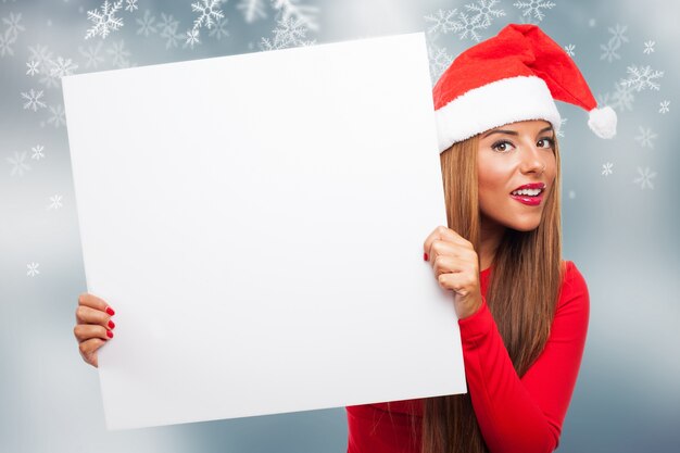 Mujer con un cartel en un fondo con copos de nieve