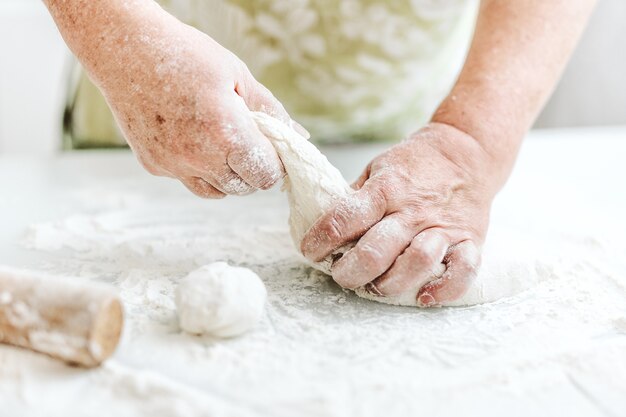 Mujer en casa amasando masa para cocinar pasta pizza o pan. Concepto de cocina casera. Estilo de vida