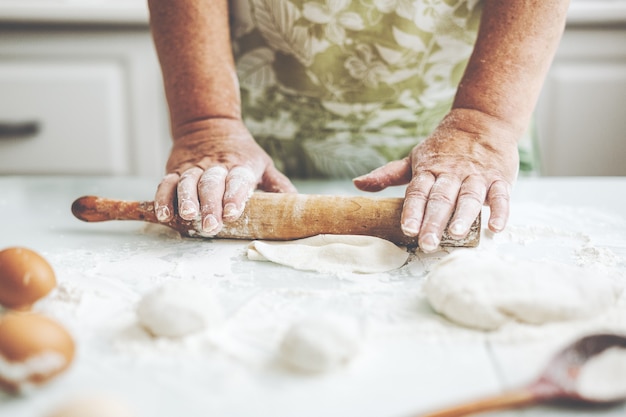 Mujer en casa amasando masa para cocinar pasta pizza o pan.