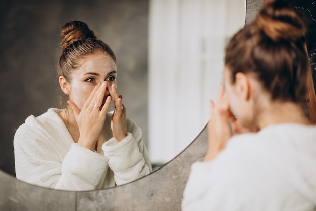 Mujer en casa aplicando mascarilla crema