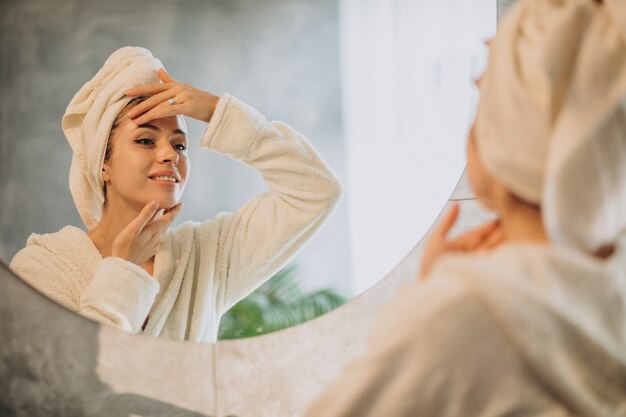 Mujer en casa aplicando mascarilla crema