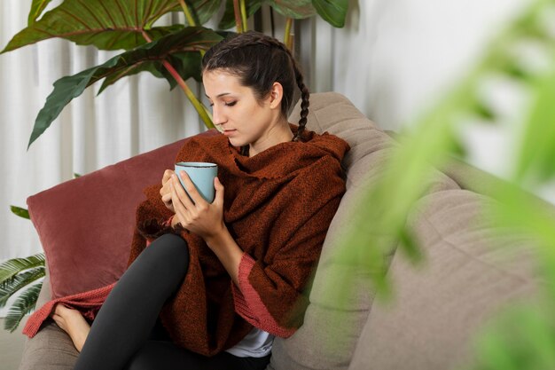 Mujer en casa bebiendo té