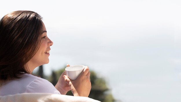 Mujer en casa disfrutando de una taza de café