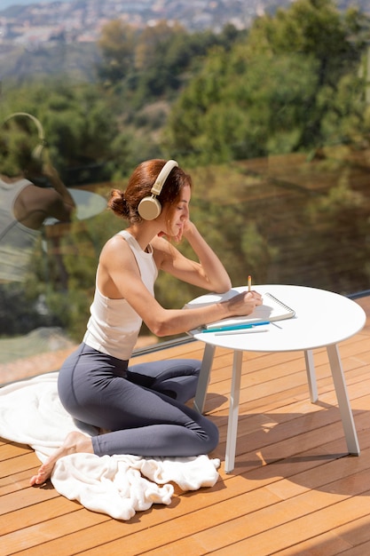 Foto gratuita mujer en casa escuchando música y dibujando