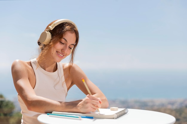 Foto gratuita mujer en casa escuchando música y dibujando