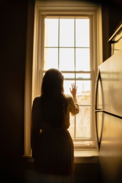 Mujer en casa con luces misteriosas a su alrededor.