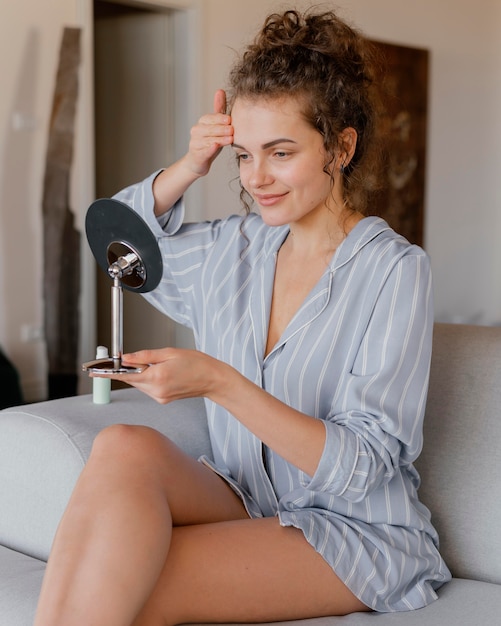 Mujer en casa mirando en el espejo