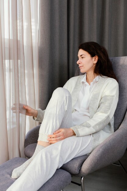 Mujer en casa mirando por la ventana