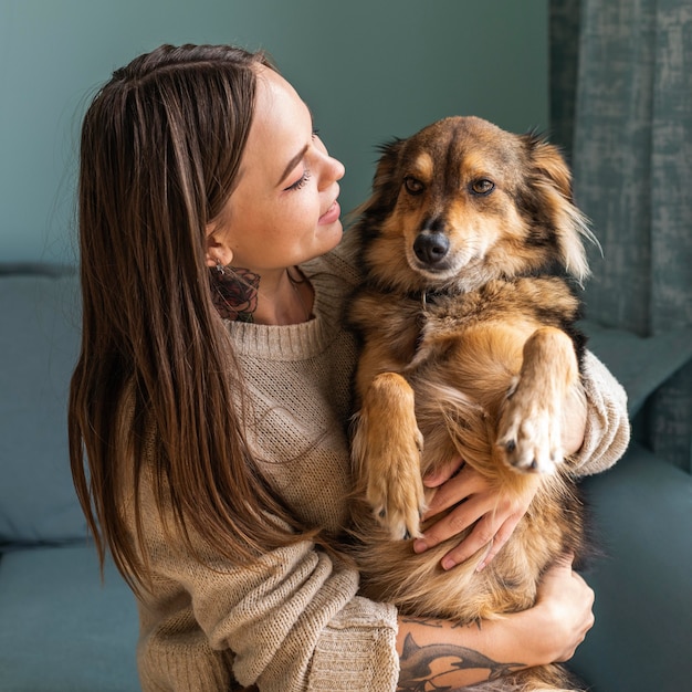 Mujer en casa sosteniendo a su lindo perro durante la pandemia