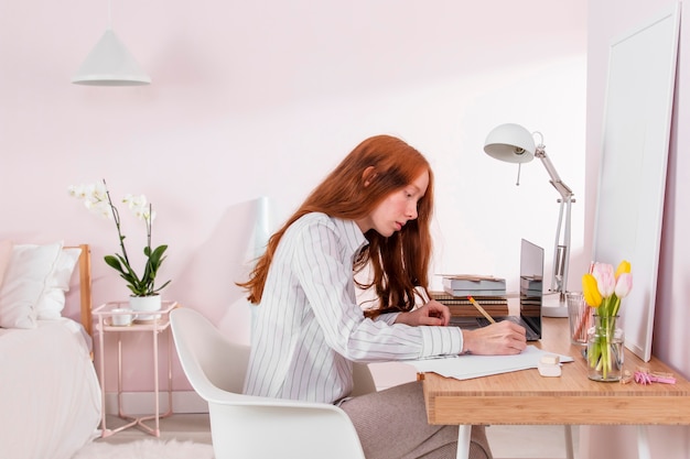 Mujer en casa trabajando en equipo portátil