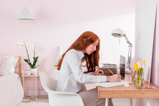 Mujer en casa trabajando en equipo portátil