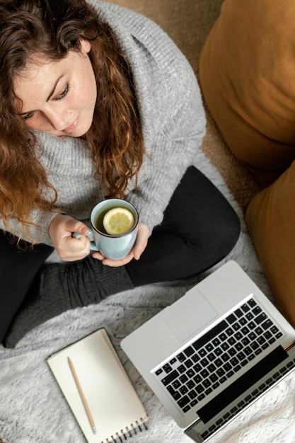 Mujer, en casa, usar la computadora portátil