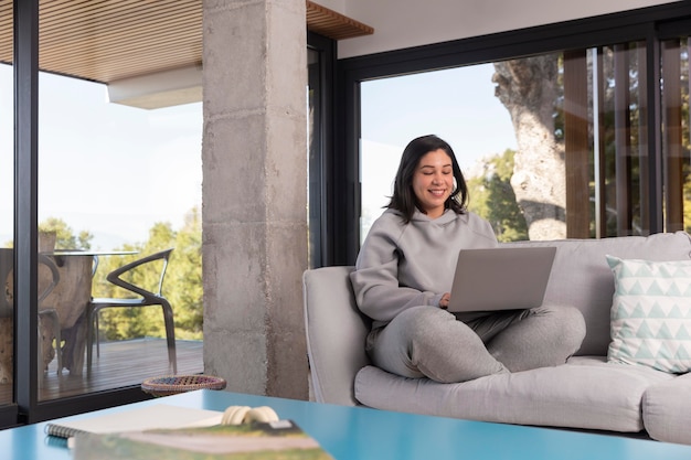 Mujer, en casa, usar la computadora portátil