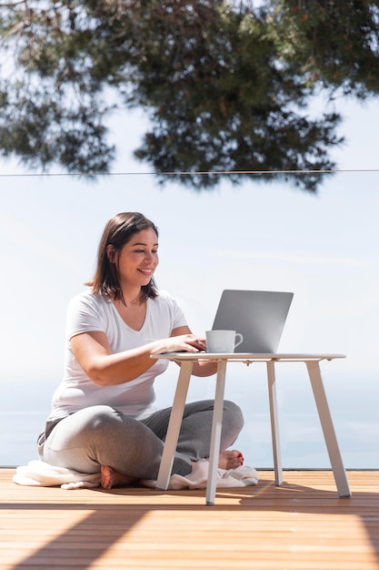 Mujer, en casa, usar la computadora portátil