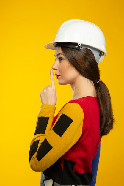 Foto gratuita mujer en casco de construcción muestra silencio