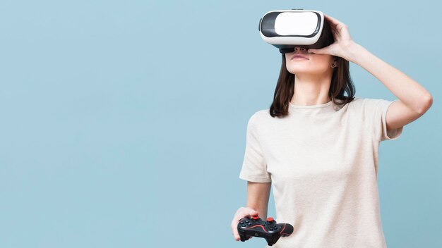 Mujer con casco de realidad virtual y control remoto