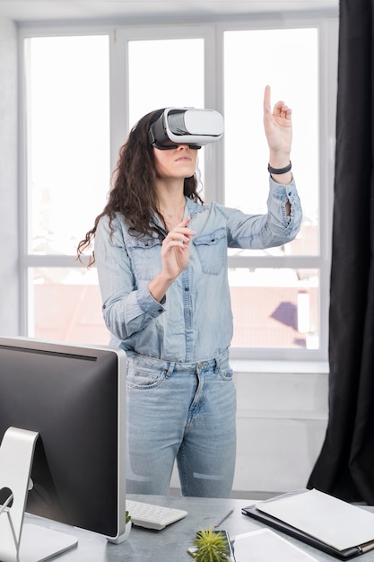 Mujer con casco de realidad virtual en interiores