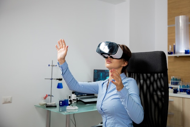 Mujer con un casco de realidad virtual con las manos en el aire.