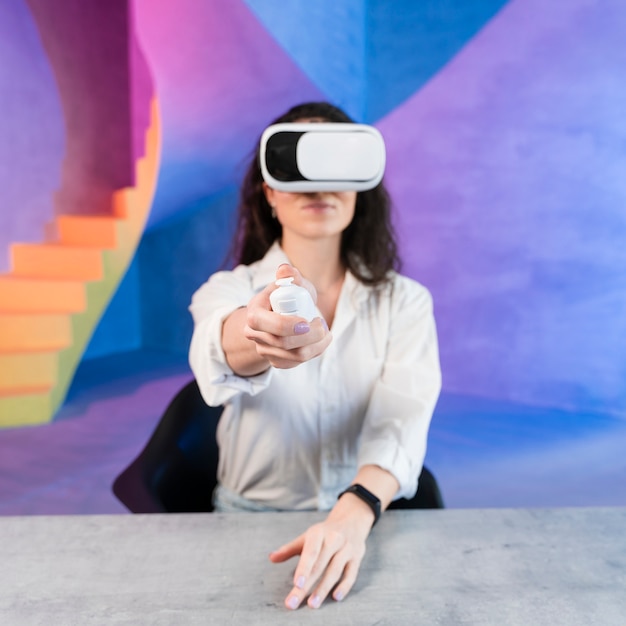 Mujer con casco de realidad virtual y sosteniendo un control remoto