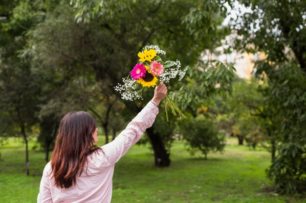 Mujer casual con flores en el parque verde