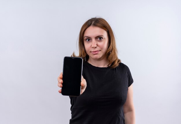 Mujer casual joven confiada que estira el teléfono móvil en el espacio en blanco aislado con el espacio de la copia