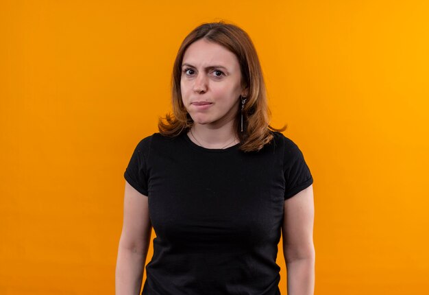 Mujer casual joven disgustada en pared naranja aislada con espacio de copia