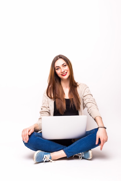 Mujer casual joven sentada sonriendo sosteniendo portátil