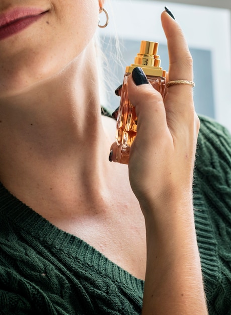Mujer caucásica aplicar perfume en el cuello