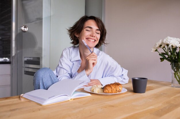 Mujer caucásica en la cocina sonriendo con los ojos cerrados