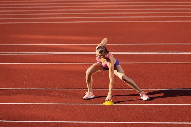 Foto gratuita una mujer caucásica corredor de la atleta practicando solo en el estadio público