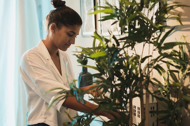 Mujer caucásica cuidando plantas caseras