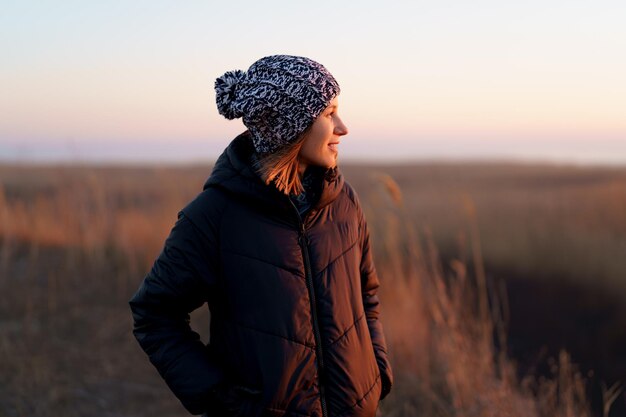 Mujer caucásica disfrutando de la vista de la naturaleza al aire libre por la noche viendo la puesta de sol