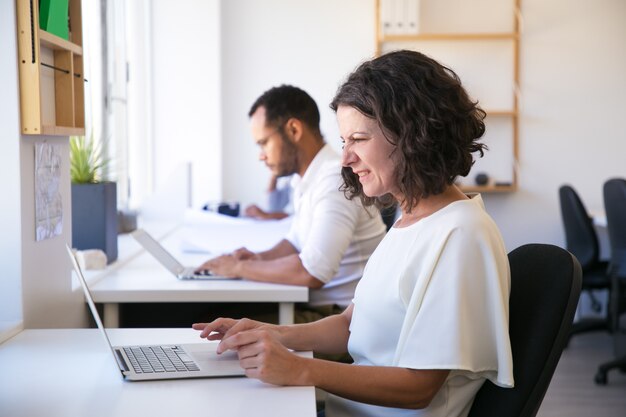 Mujer caucásica enojada que trabaja con la computadora portátil