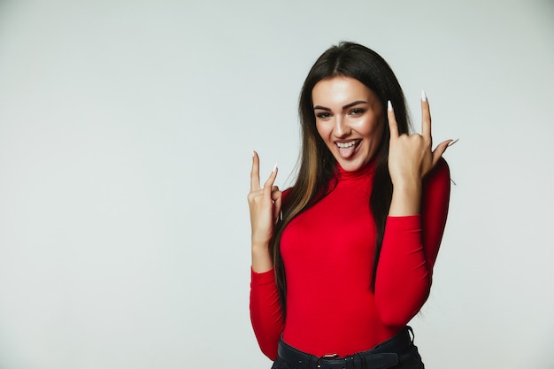 Mujer caucásica haciendo signo de rock