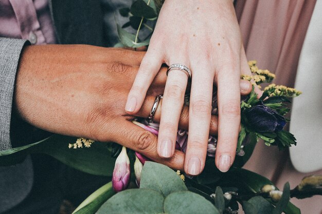 Una mujer caucásica y un hombre afroamericano con anillos y sosteniendo flores Concepto de diversidad