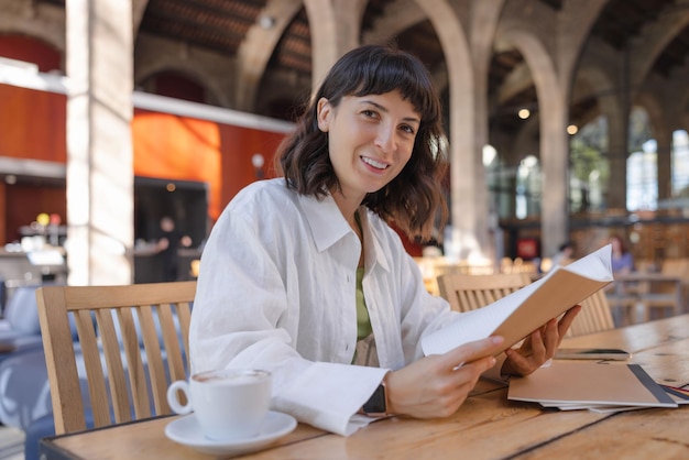 Mujer caucásica joven en café sonriendo a la cámara